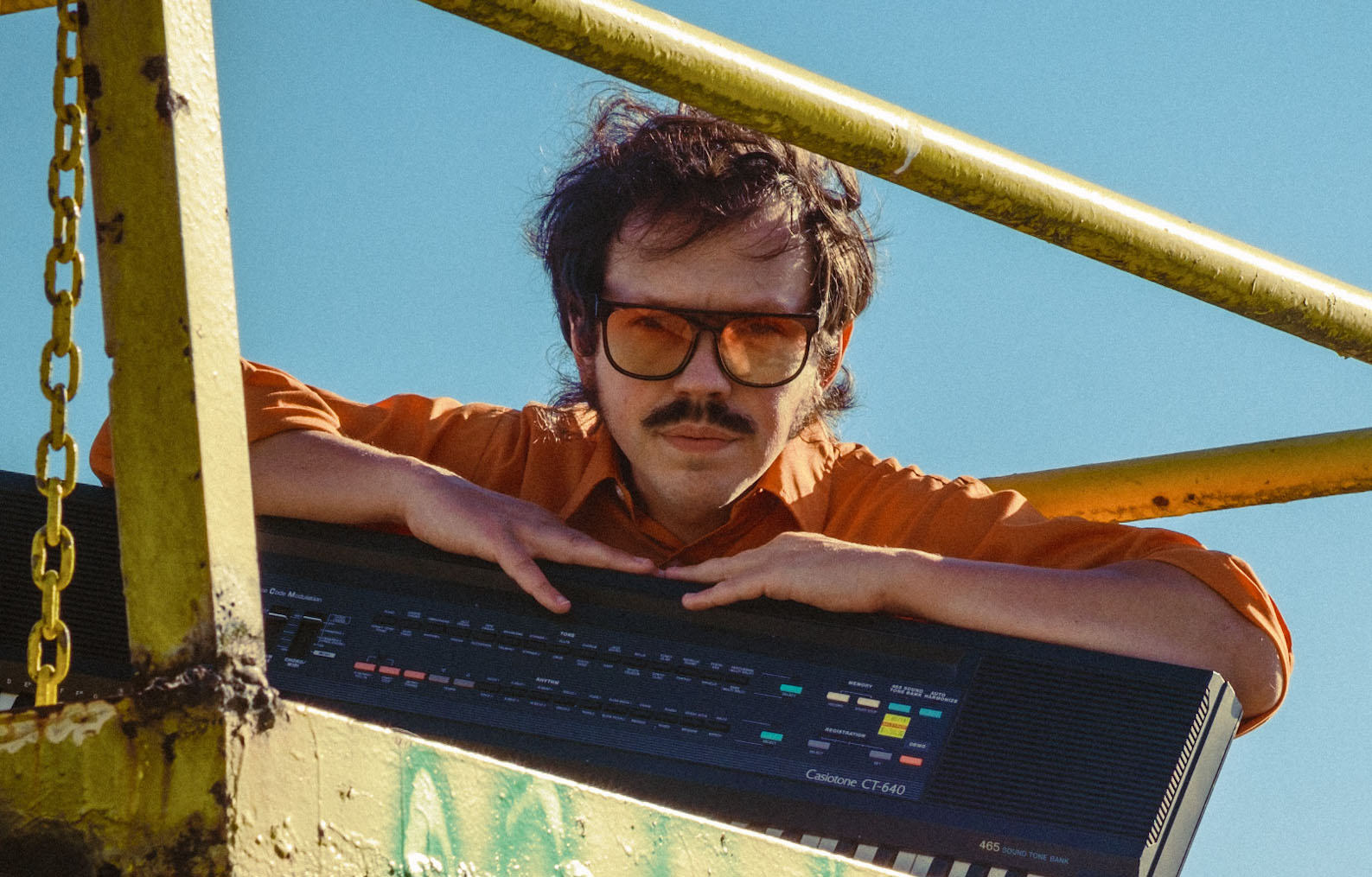 Brett Sisun in sunglasses with a keyboard.