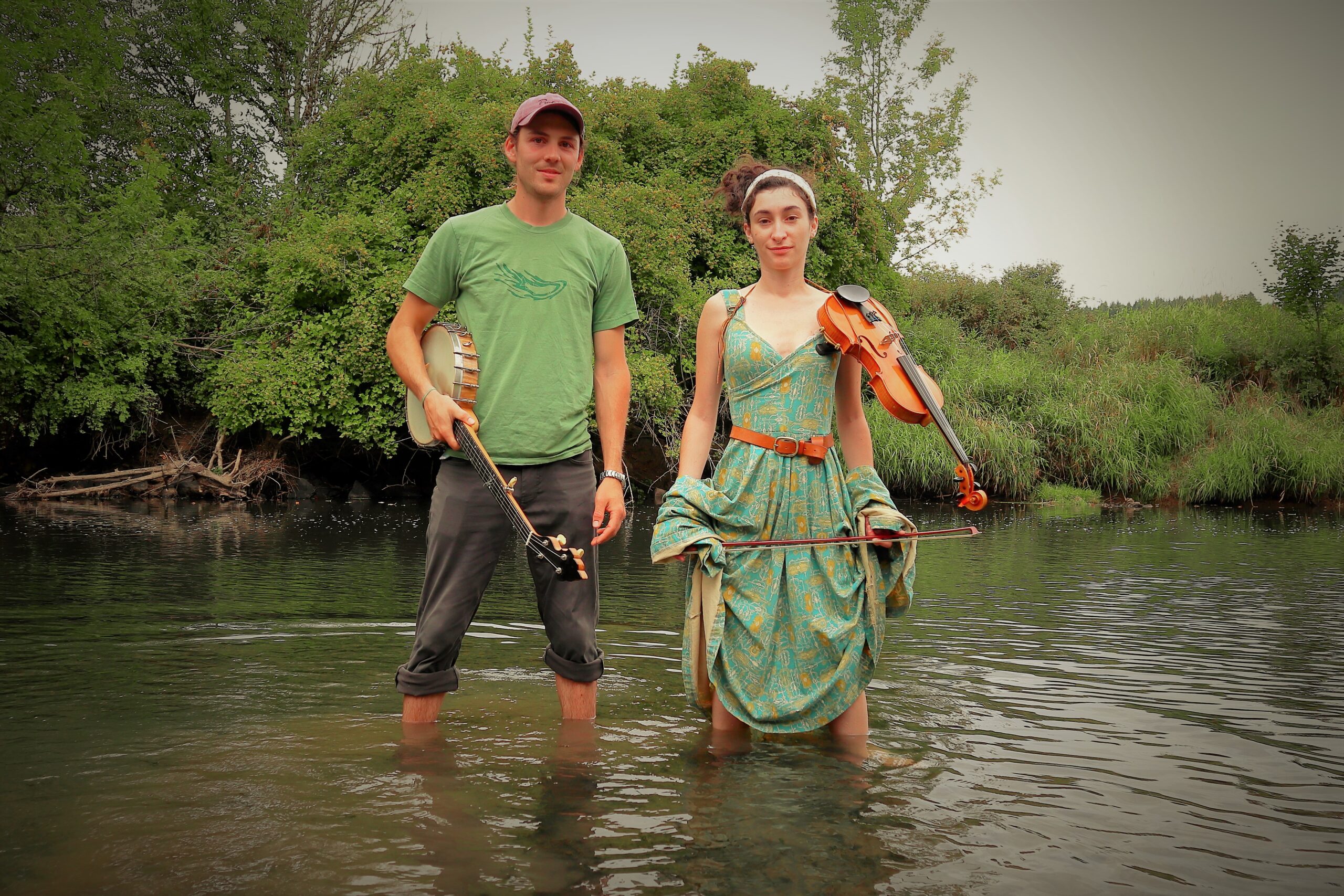 Mid shot of the Dear Crow musicians, standing in a creek.